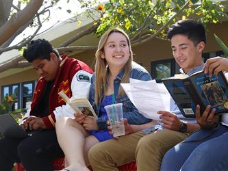 Students sitting on a bench reading